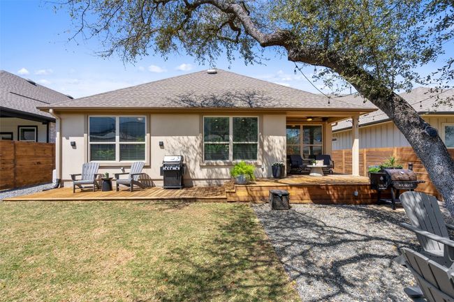Back of property with a wooden deck, stucco siding, roof with shingles, and an outdoor living space | Image 29