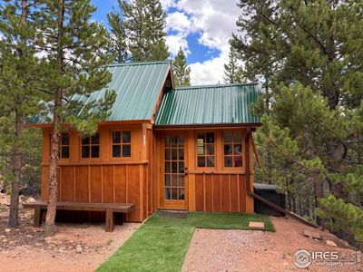 Cozy, cottage style shed with metal roof. | Image 1