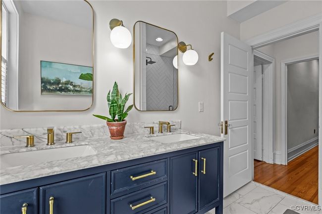 Bathroom with a tile shower, double vanity, marble finish floor, and a sink | Image 22