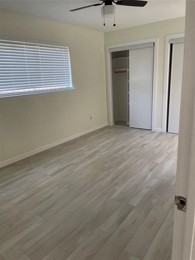 Unfurnished bedroom with wood finished floors, baseboards, and a ceiling fan | Image 9
