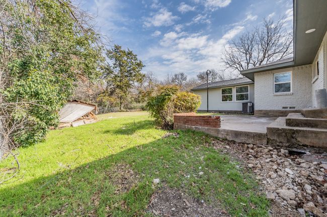 View of green lawn with a patio area and cooling unit | Image 22
