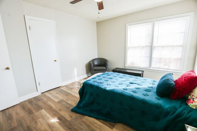 Bedroom featuring ceiling fan, a textured ceiling, baseboards, and wood finished floors | Image 27