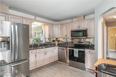 At the heart of the home is the amazing, updated kitchen with lovely granite countertops | Image 3