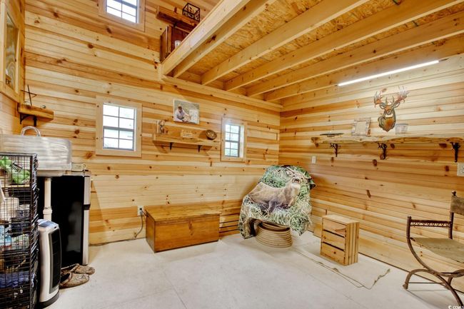 Living area with wooden walls and concrete floors | Image 32