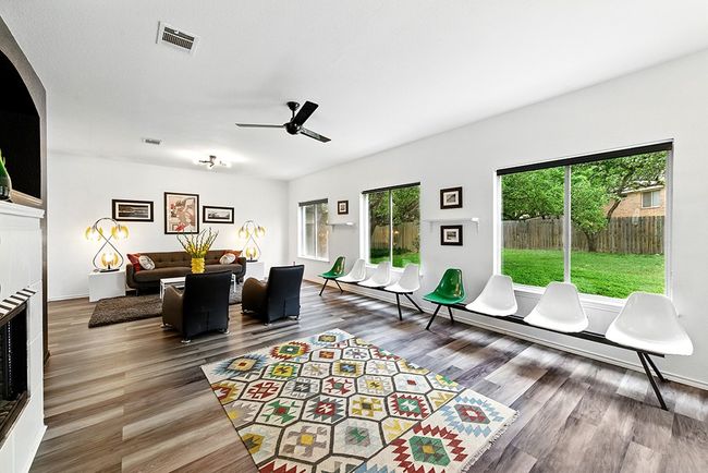 Detailed view of freestanding refrigerator, wood finished floors, a textured wall, a tile fireplace, and arched walkways | Image 14