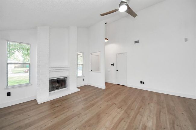 Spacious living room with cozy fireplace. | Image 6