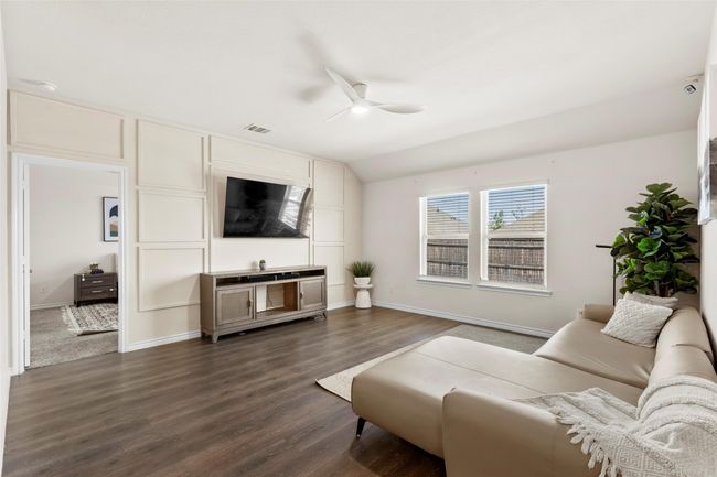 Living area featuring vaulted ceiling, a ceiling fan, dark wood finished floors, baseboards, and visible vents | Image 6