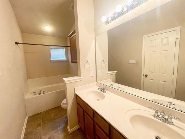Bathroom with a bath, toilet, double vanity, baseboards, and tile patterned​​‌​​​​‌​​‌‌​‌‌​​​‌‌​​‌‌​‌​​​​​‌ flooring | Image 12