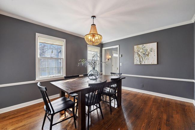 Formal dining room with rich wood floors and a pretty new light fixture. | Image 6