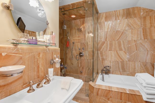 The Primary Bath with jetted tub, glass shower enclosure and pedestal sink. | Image 18