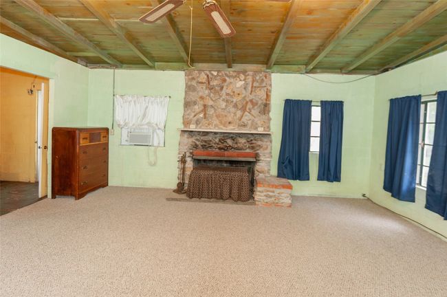 Unfurnished living room featuring cooling unit, carpet floors, beamed ceiling, ceiling fan, and wood ceiling | Image 15