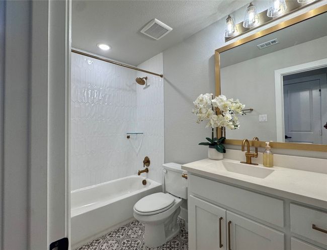 Bathroom featuring tub / shower combination, vanity, and tile patterned flooring | Image 33