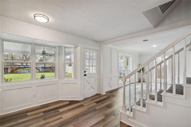 The bright breakfast area features large windows with a view of the backyard, showcasing a colorful mural. The space is bright with natural light, and offers a sleek, modern look. | Image 13