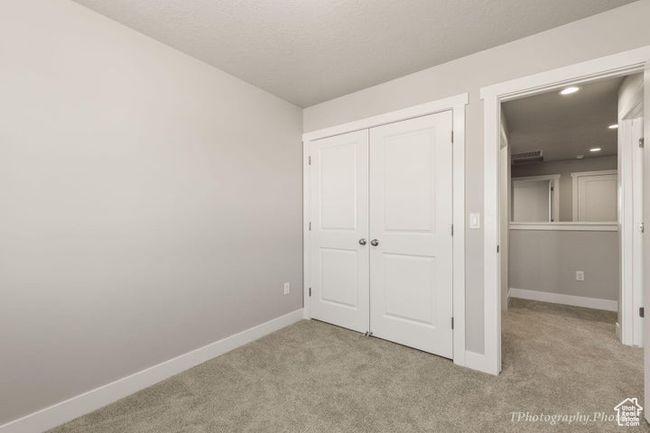 Unfurnished bedroom with light colored carpet, baseboards, a closet, and recessed lighting | Image 10
