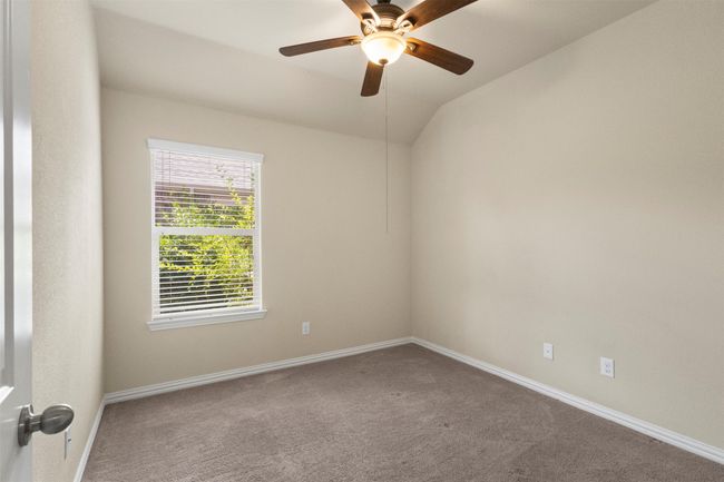 Empty room with carpet, a ceiling fan, and lofted ceiling | Image 27