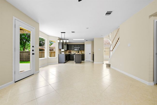 Unfurnished living room with light tile patterned floors and stairway | Image 15