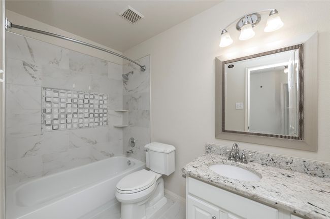 2ndary bathroom with updated shower and counter tops, mirror and lighting feature. | Image 34
