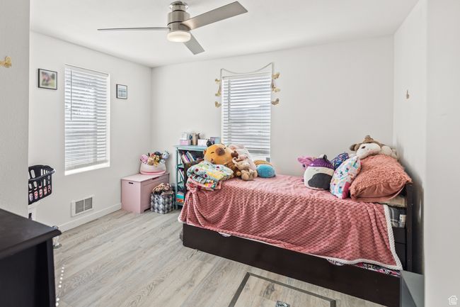 Bedroom featuring wood finished floors, a ceiling fan, and baseboards | Image 10