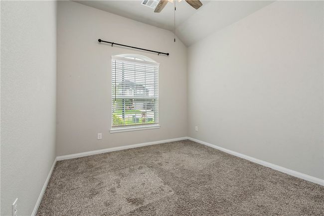 Empty room with a ceiling fan, carpet, and lofted ceiling | Image 15