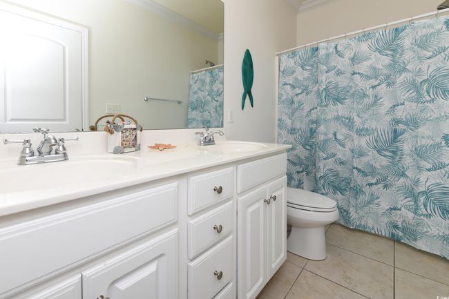 Full bathroom featuring tile patterned flooring, crown molding, and a sink | Image 16