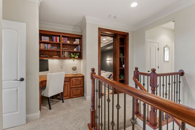 Upstairs with view of office nook and bookcase with opening to hidden media room. | Image 23