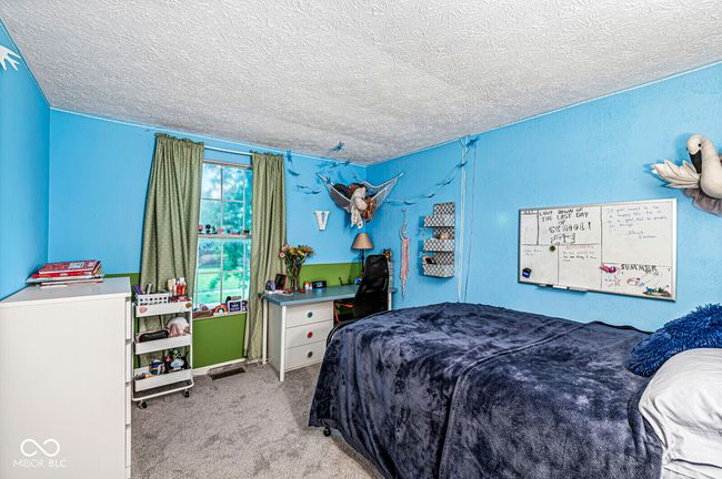 carpeted bedroom with a textured ceiling | Image 17