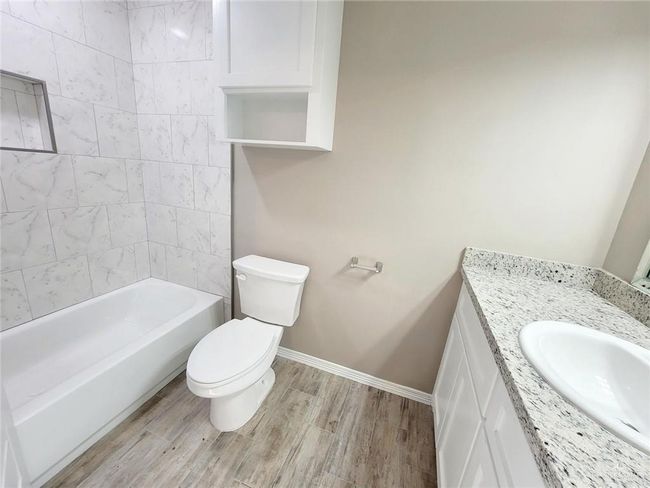 Full bathroom featuring vanity, wood finished floors, and shower / bath combination | Image 18