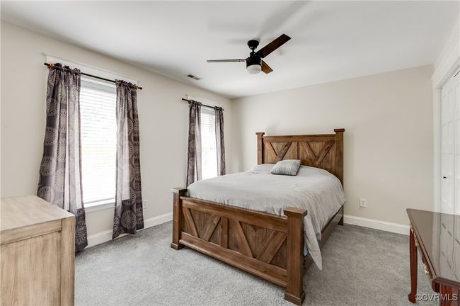 Bedroom featuring baseboards, a ceiling fan, visible vents, and carpet | Image 32