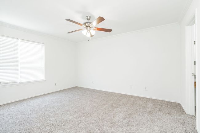 Carpeted spare room featuring crown molding, baseboards, and a ceiling fan | Image 20