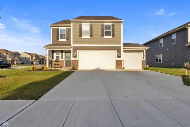 view of front of property featuring concrete driveway, a front yard, brick siding, and an attached garage | Image 39