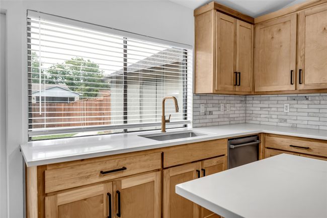 Kitchen with a sink, decorative backsplash, light countertops, light brown cabinetry, and dishwasher | Image 18