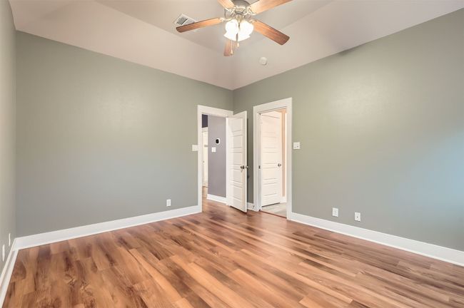 Spare room with wood finished floors, a ceiling fan, and a smoke detector | Image 14