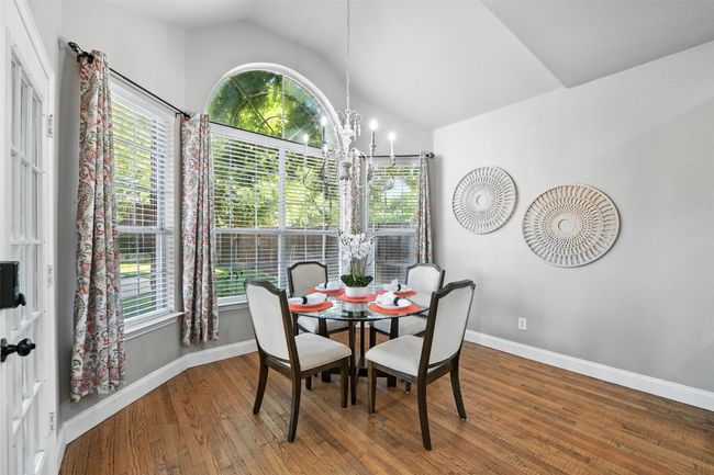 Dining space with vaulted ceiling, a chandelier, plenty of natural light, and wood finished floors | Image 12