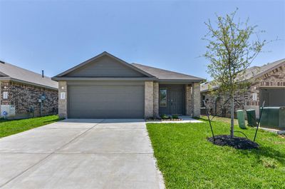 A modern single-story home with a two-car garage, great curb appeal and a neat brick facade. | Image 1