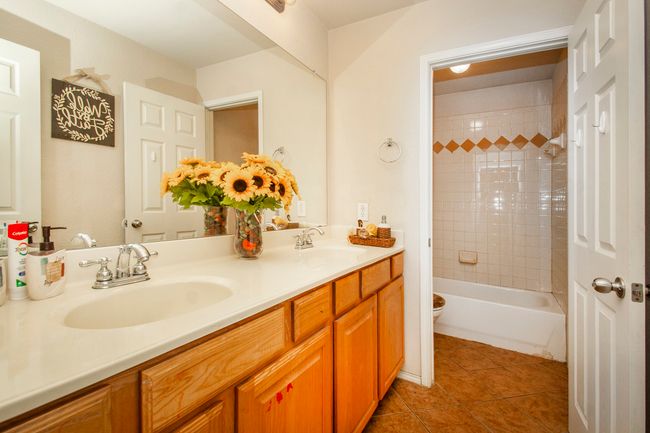 Bathroom featuring double vanity, toilet, tile patterned flooring, and bathtub / shower combination | Image 21