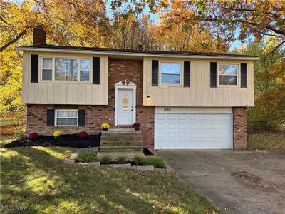 Split foyer home featuring a front lawn and a garage | Image 1