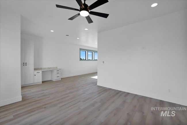 Unfurnished room with ceiling fan, light wood finished floors, recessed lighting, and built in study area | Image 23