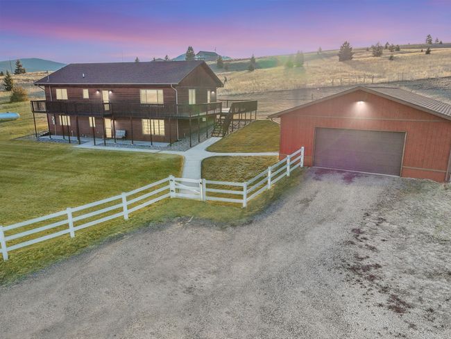 View of front of house with fence private yard, an outdoor structure, driveway, a front lawn, and a garage | Image 55