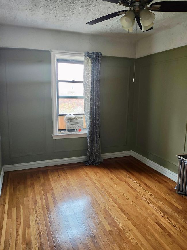 Unfurnished room with light wood-type flooring, a ceiling fan, baseboards, and a textured ceiling | Image 20