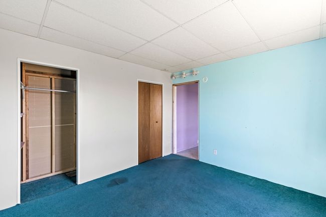 Unfurnished bedroom featuring two closets, a paneled ceiling, and carpet floors | Image 28