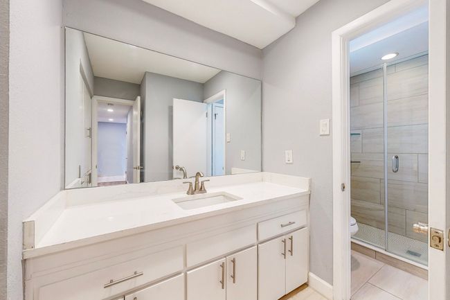 Full bath featuring a shower stall, tile patterned flooring, vanity, and toilet | Image 9