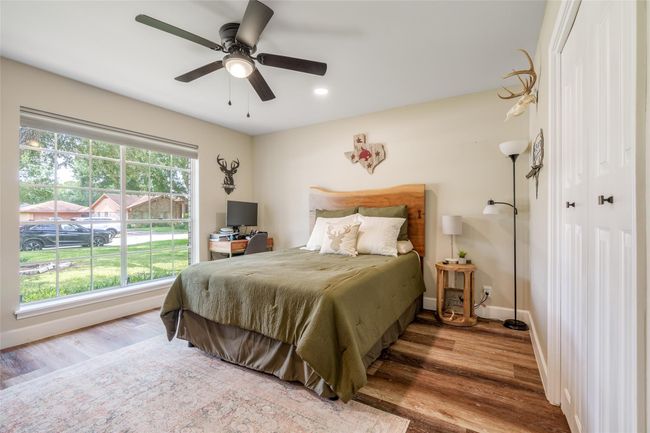 This stunning bedroom boasts custom paint, a large window with privacy blinds, and elegant vinyl plank flooring, creating a warm and inviting space! | Image 13