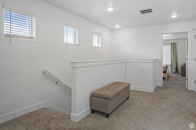 Living area featuring recessed lighting, carpet flooring, an upstairs landing, visible vents, and baseboards | Image 10