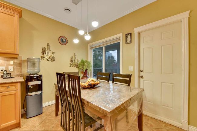 Dining room with light tile patterned flooring, crown molding, and baseboards | Image 22