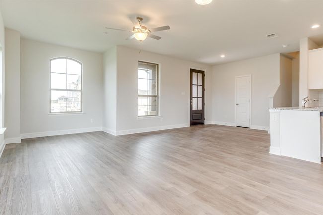 Unfurnished living room featuring ceiling fan, sink, and light hardwood / wood-style floors | Image 10