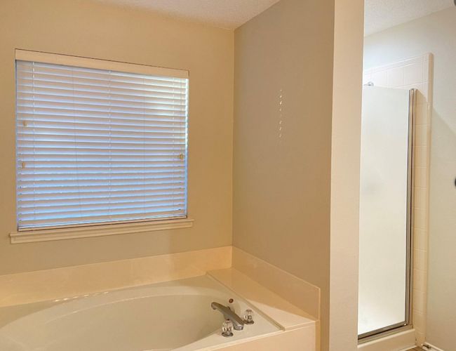 Bathroom with a stall shower, a garden tub, and a textured ceiling | Image 16