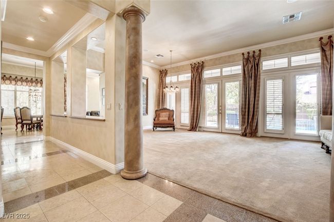 Unfurnished living room with baseboards, decorative columns, visible vents, and crown molding | Image 6