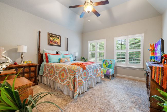 Bedroom featuring light colored carpet, a ceiling fan, and vaulted ceiling | Image 31