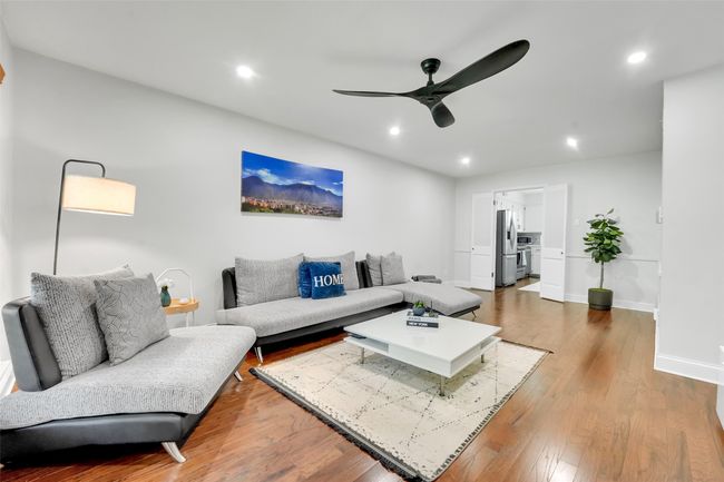 Unit 7340 - Living area with ceiling fan, wood finished floors, and recessed lighting | Image 22