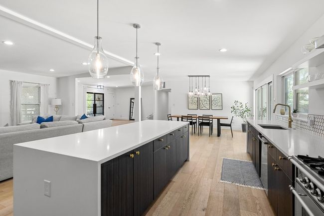 Kitchen featuring recessed lighting, light countertops, a center island, a sink, and high end stove | Image 11